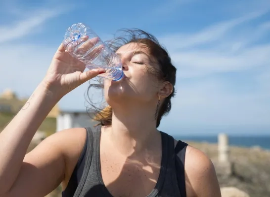 Vrouw drinkt water uit een flesje Vrouw drinkt water uit een flesje
