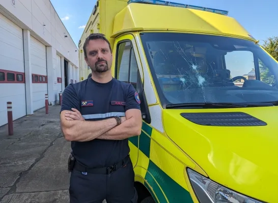 Hulpverlener bij beschadigde ambulance