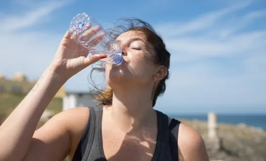 Vrouw drinkt water uit een flesje