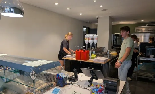 Nora Smets werkende in haar nieuwe broodjeszaak