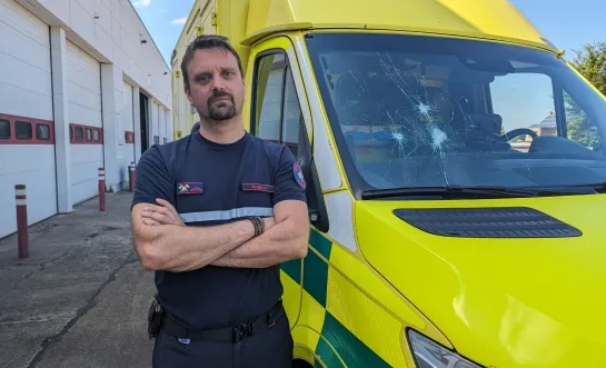 Hulpverlener bij beschadigde ambulance