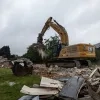 Een aannemer sloopt de leegstaande woningen in Mechelen-Zuid